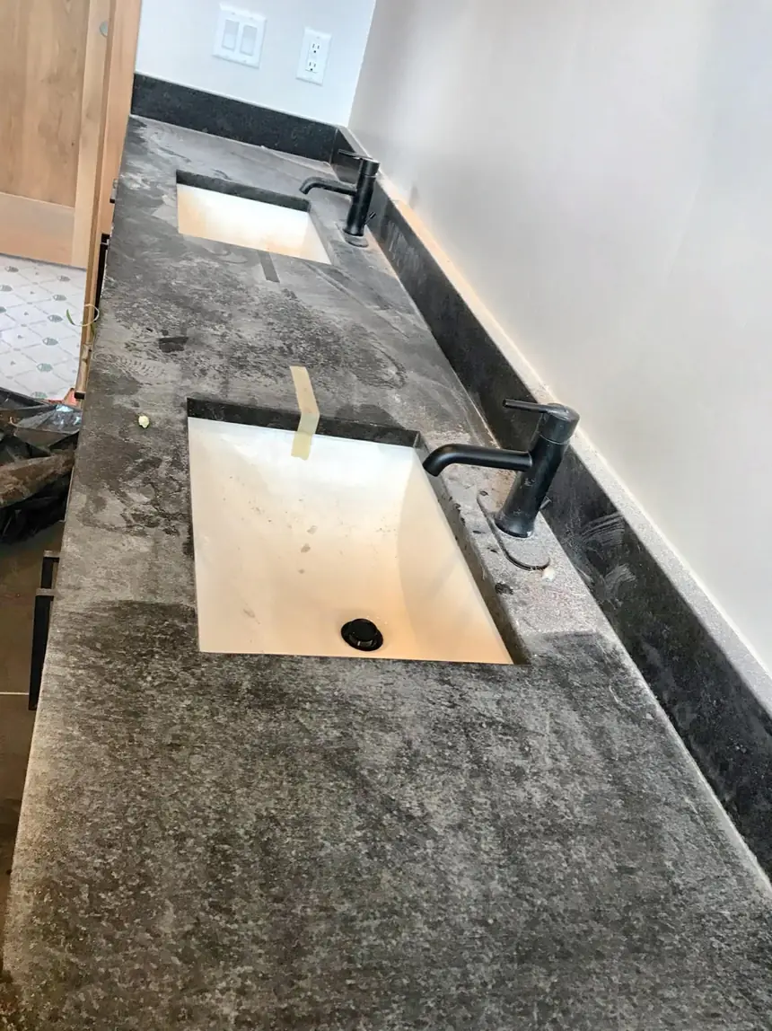 Before: dusty stone vanity and sink before a final detail clean