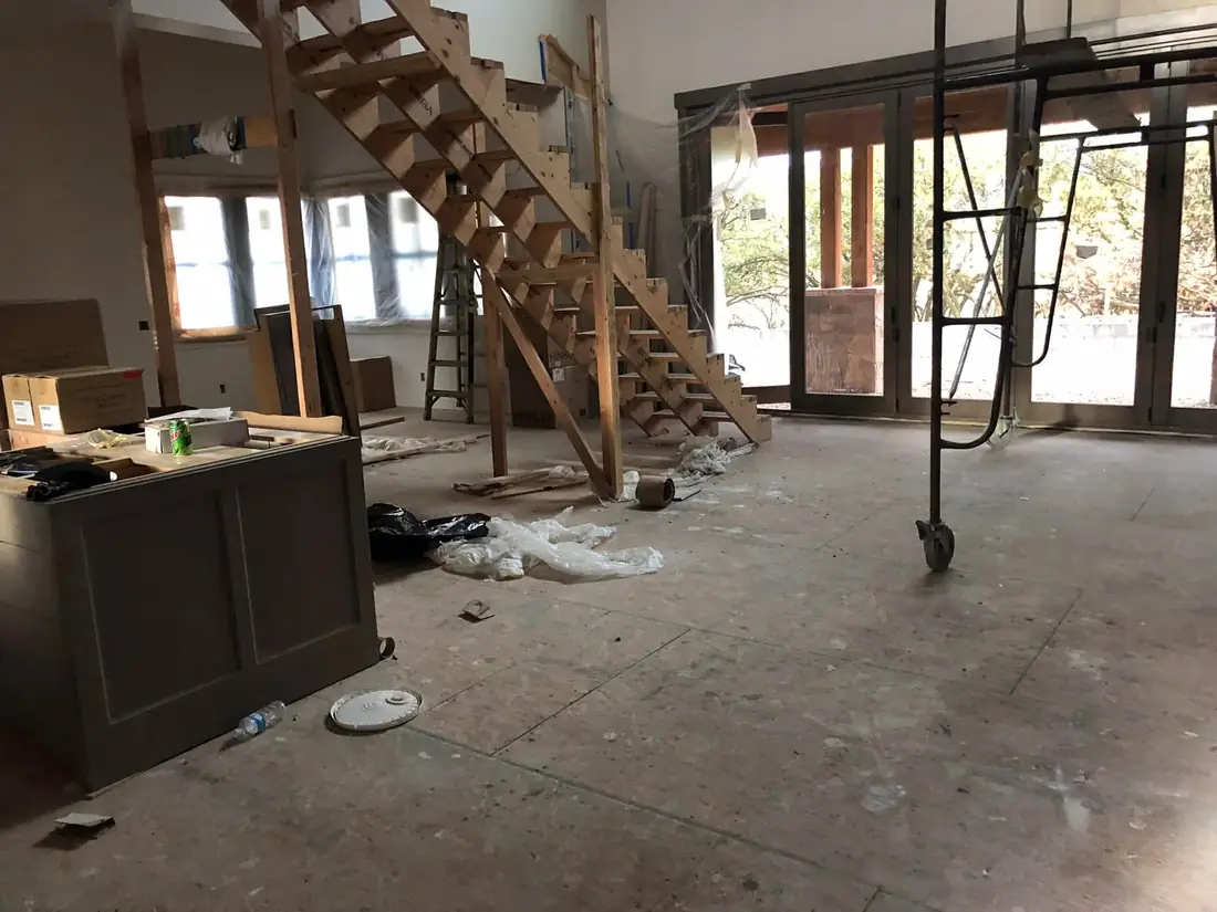 Before a rough clean: open-concept framing stage with scrap, packaging, and debris on the subfloor